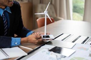 Sustainable Energy Model Presentation. Businessman showcasing wind turbine. photo