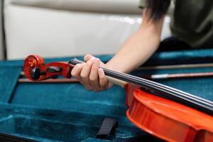 Music Instruments and Learning. A close-up of a child's hand holding a violin in a case. photo