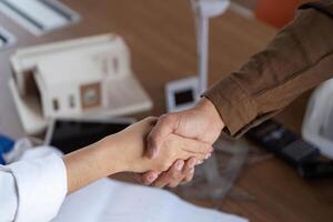 Collaborative Efforts in ESG. Close-up of architects shaking hands on a project. photo