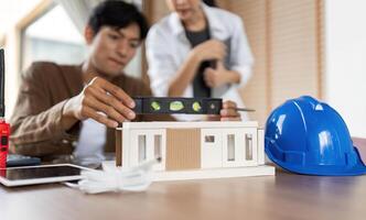 ESG in Architecture. Professionals collaborating on sustainable building design with a model. photo
