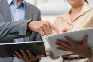 Close-Up of Professional Interaction. Business partners discussing data on tablets. photo