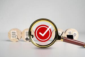 Magnifying Glass Focuses on Red Check Mark with Document Icons, Quality Control and Verification Concept photo