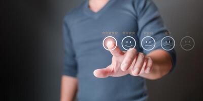 man touches icon on the happy smile face and gives five stars to indicate satisfaction with the service. Feedback, survey, and review concept. Rating Very impressed. photo