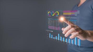 businessman interact with a glowing virtual dashboard displaying analytics and charts, emphasizing data analysis, business insights, and modern technology for decision making and performance tracking. photo