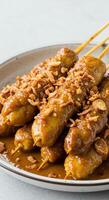 Delicious Indonesian Satay Skewers in Rich Peanut Sauce, Garnished with Crispy Fried Onions photo