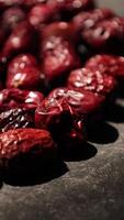 a close up of dried dates on a black surface, closeup of a dried fruit video