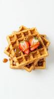 Delicious Golden Waffles Topped with Strawberries and Caramel Sauce photo