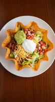 Delicious Taco Salad in Crispy Bowl Fresh lettuce, seasoned ground beef, guacamole, pico de gallo, cheese, and sour cream. photo
