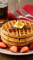 Delicious golden waffles drizzled with maple syrup and served with fresh strawberries a perfect breakfast treat photo