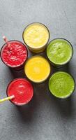 Refreshing fruit smoothies in vibrant red, yellow, and green colors, perfect for a healthy and delicious breakfast or snack. photo