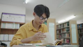 University student researching in the library and reading a book. video