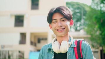 Smiling student standing on university campus happy looking at the camera. video