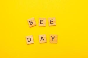 Top view of World bee day text on yellow background. photo