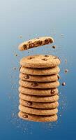 Delicious Chocolate Chip Cookies Stack Falling with crumbs against a blue background photo