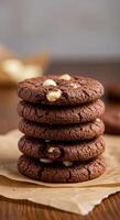 Delicious double chocolate cookies with white chocolate chips, stacked high on brown paper for a tempting treat. photo