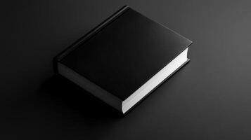 An elegant black book lying on a monochrome surface and displaying a minimalist design. Mockup photo