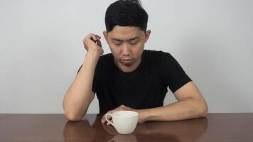 Man sit and feel sleepy with coffee cup on table video
