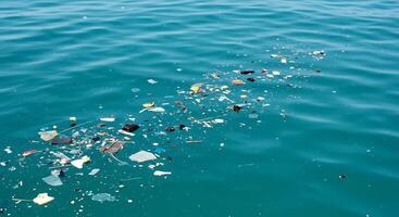 A boat is floating in the ocean with trash floating around it photo