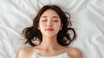 Serene soft portrait of asian woman on white bedsheets relaxing bedroom environment photo