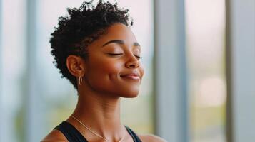 Mindful meditation practice by a smiling woman in workout clothes indoor studio setting photo