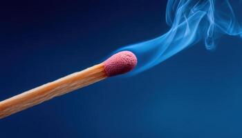 Slow motion ignition of a matchstick close-up shot symbolic moment blue background photo