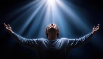 Person praying with light rays shining down in spiritual atmosphere photo
