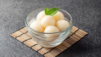 Refreshing lychee ice dessert in glass bowl on bamboo mat minimalist setup elegant presentation photo