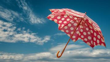 Pink Polka Dot Umbrella Soaring in a Blue Sky photo