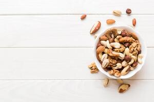 mixed nuts bowl. Mix various nuts colored background. pistachios, hazelnuts, peanuts and brazil nuts photo