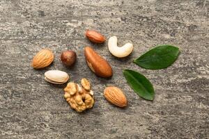 Composition of nuts , mix hazelnuts, cashews, almonds on table background. healthy eating concepts and food background photo