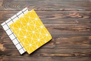 top view yellow empty kitchen napkin isolated on table background. Folded cloth for mockup with copy space, photo