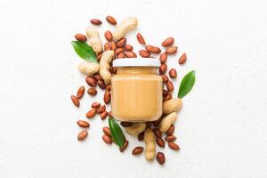 Bowl peanut butter and peanuts table background. top view copy space. Creamy peanut pasta photo