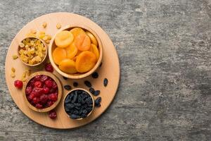 Bowl with different dried fruits on table background, top view. Healthy lifestyle photo