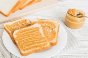 Peanut butter sandwiches toasts light table background. Breakfast. American cuisine top view photo