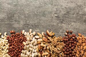 different nuts frame background. flat lay with vopy space. Walnut, pistachios, hazelnuts and cashews photo