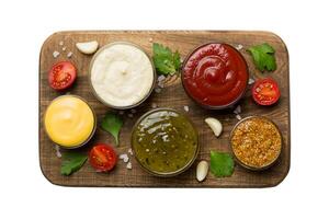 Many different sauces and herbs isolated on white background, flat lay top view. sauces on plate photo