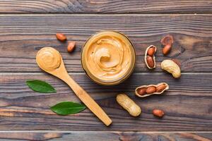 Bowl peanut butter and peanuts on table background. top view with copy space. Creamy peanut pasta photo
