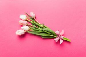 Bouquet pink tulips on colored table background . Top view with copy space. Waiting for spring. Happy Easter card. Flat lay photo