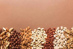 different nuts frame background. flat lay with vopy space. Walnut, almonds, hazelnuts and cashews photo