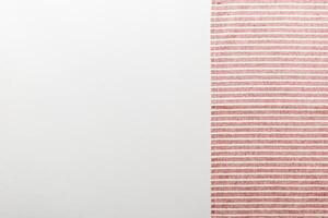 top view with red empty kitchen napkin isolated on table background. Folded cloth for mockup with copy space. photo