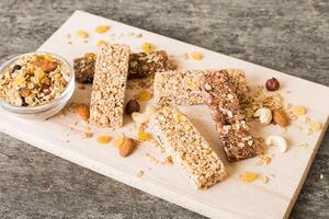 Various granola bars on table background. Cereal granola bars. Superfood breakfast bars with oats, nuts photo