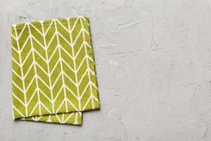 top view green kitchen napkin isolated on table background. Folded cloth for mockup with copy space, photo