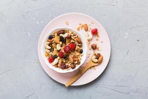 Cooking wholesome breakfast. Granola with Various dried fruits and nuts in a bowl. The concept of healthy dessert. top view with copy space photo