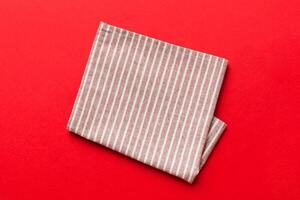 top view red empty kitchen napkin isolated on table background. Folded cloth mockup with copy space, photo