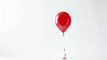 Single red balloon on white background photo