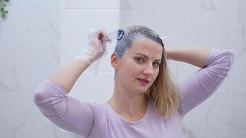 Transforming hair with vibrant color in a bright bathroom setting video