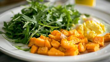 This Nutritious meal showcases vibrant greens, roasted sweet potatoes, and scrambled eggs on a plate. photo