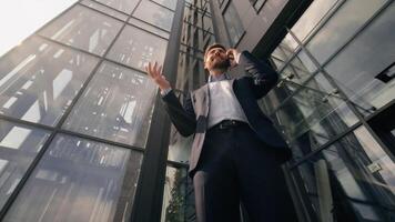 Bottom view smiling successful business man talking mobile phone happy discuss work deal with smartphone businessman male speaking cellphone consulting client communicate in city near office building photo
