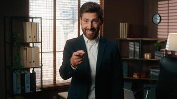 Happy smiling man male recruiter mature businessman index finger hey you gesture pointing at wrist like wristwatch showing time late invite join business team office inviting come here welcome hiring photo