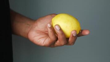 Hand holding a fresh lemon, no background video